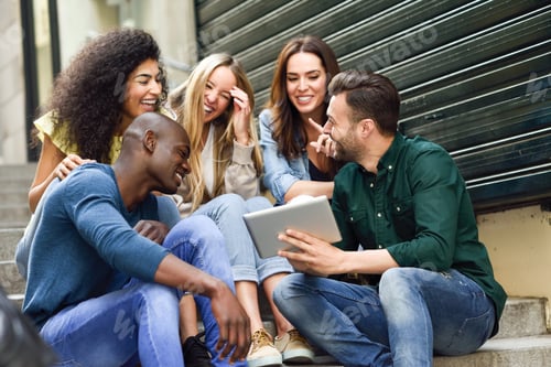 Preview: Multi-ethnic group of young people looking at a tablet computer outdoors in urban background. Group