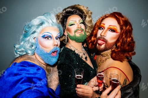 Preview: POV of happy drag queens taking a selfie standing with champagne glasses