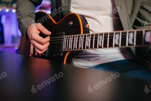 Preview: Musician composing music playing electric guitar at home
