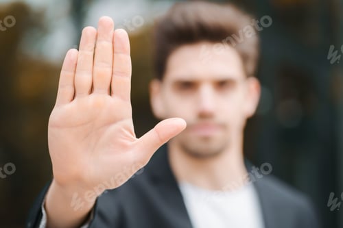 Preview: Portrait of young businessman disapproval gesture with hand: denial sign, no sign, negative