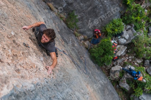 Preview: Man rock climbing on limestone rock, overhead view, Ha Long Bay, Vietnam