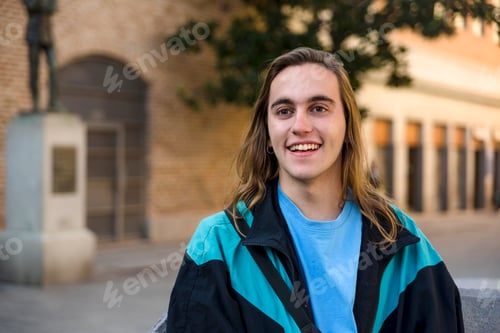Preview: Man smiling while sitting outdoors at the street.