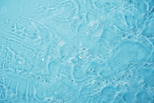 Preview: Close up macro Aloe vera gel cosmetic texture blue background with bubbles