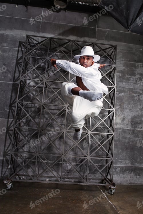 Preview: Energetic African American male dancer jumps and twirls in studio, executing pirouettes