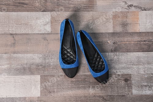 Preview: Pair of female shoes on wooden background, top view