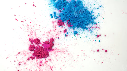Preview: Top view of dry colorful inks falling in white liquid substance. Beautiful iridescent background of
