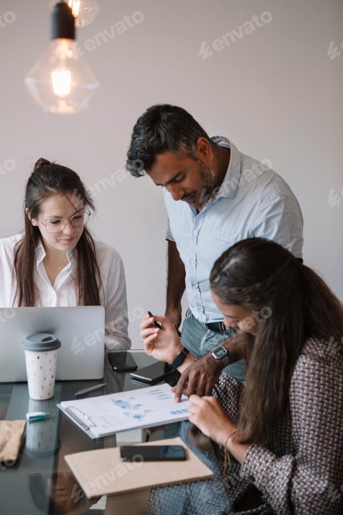 Preview: Colleagues working together at table in office