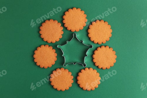 Preview: Gingerbread cookies and metallic cutter on green background.