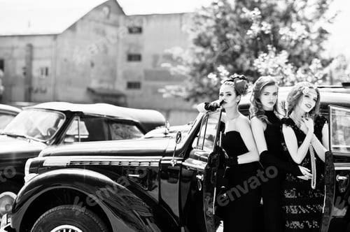 Preview: Three young girl in retro style dress near old classic vintage cars.
