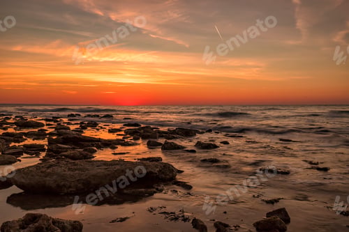 Ocean Waves Crashing on Rocky Shoreline at Sunset