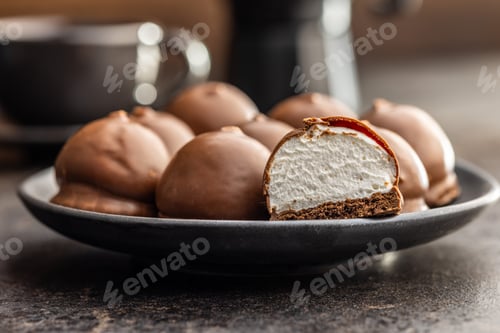 Preview: Chocolate covered marshmallows. Sweet dessert on plate.