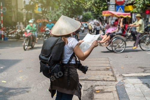 Preview: Asian Traveler holding and looking the map for travel at the hanoi city, vietnam