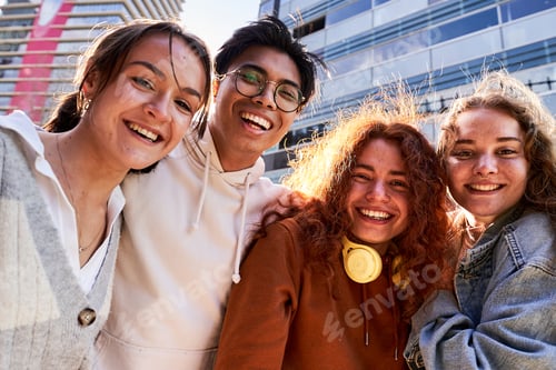 Preview: Cheerful portrait of a small group of interracial student friends, looking at camera smiling.