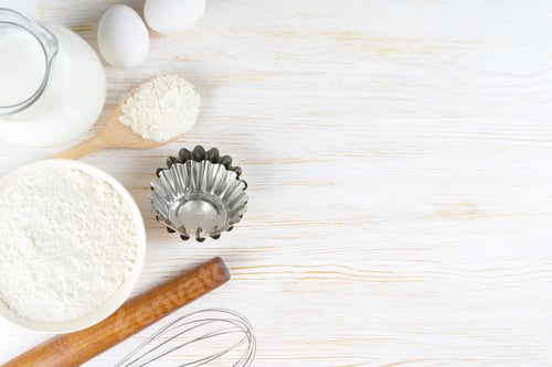 Preview: Baking Ingredients Flour, Eggs, Milk, Bakeware on White Wooden Background With Copy Space