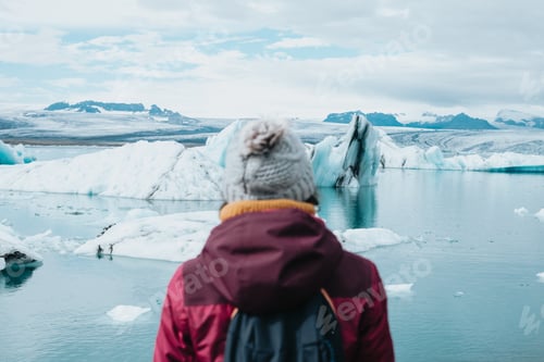 Preview: A female tourist is standing in front of jokulsarlon glacial lagoon. Ice beach, Breidamerkursandur,