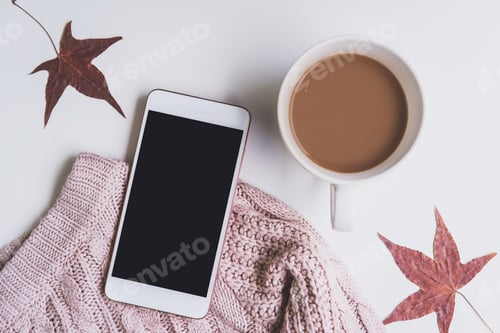 Preview: Empty screen smartphone with cup of coffee and dried autumn leaves and sweater, Top view