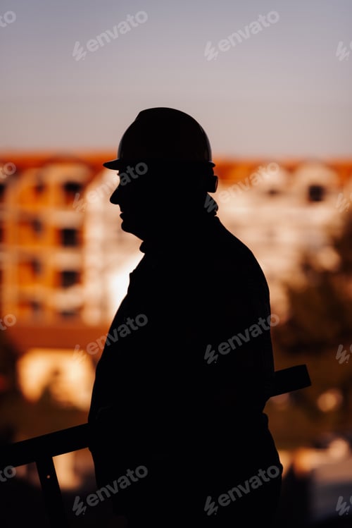 Preview: Construction site silhouette: foreman overseeing building progress at sunset