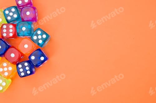 Preview: Top view of colorful plastic dice against an orange background with space for text