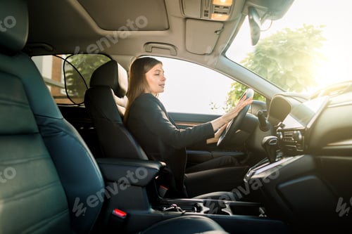 Preview: Beautiful young brunette woman in business suit driving a car to office. Businesswoman drive a car