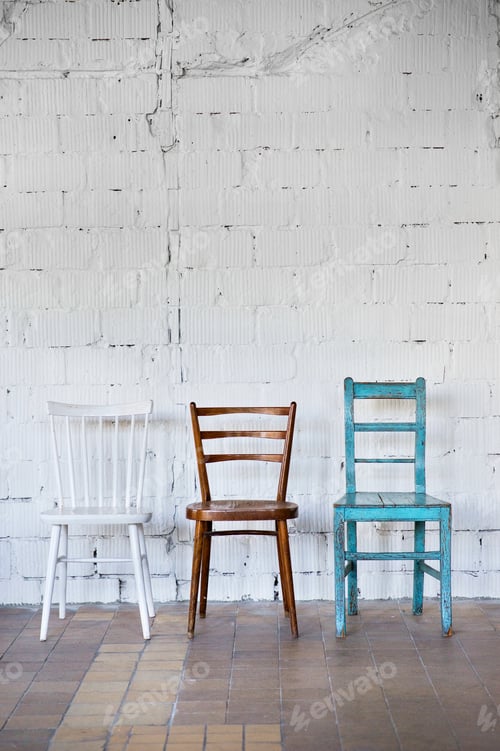 Preview: Empty chairs against white brick wall