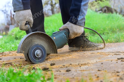Preview: An angle grinder hand saw is used by a worker when cutting metal