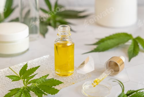 Preview: Opened Dropper bottle with pipette near green cannabis leaves. CBD oil