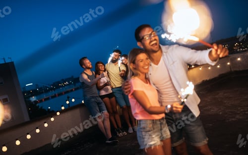 Preview: Friends enjoying a rooftop party and dancing with sparklers