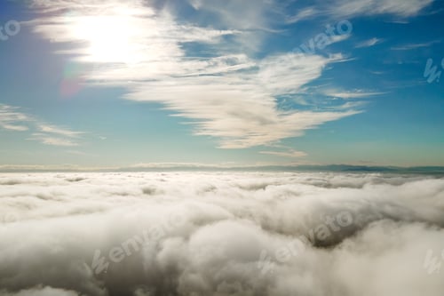Preview: Aerial view from above of white puffy clouds in bright sunny day.