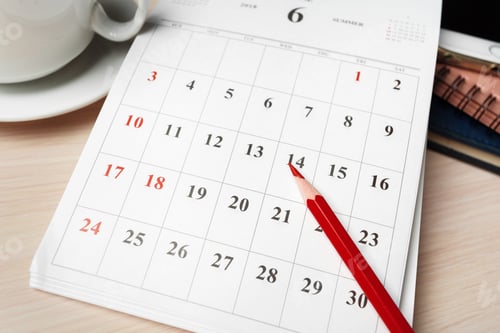 Preview: Calendar page showing June dates with red pencil and coffee cup on wooden table