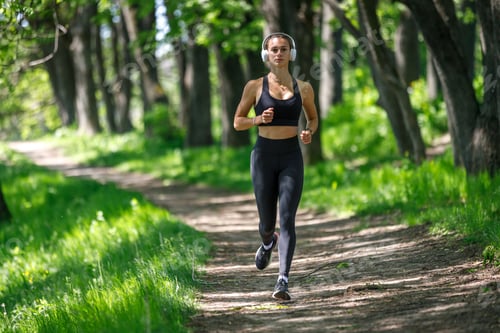 Preview: Young fitness woman jogging in park at sunny morning