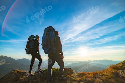 Preview: The couple standing on the mountain with a picturesque sunrise background