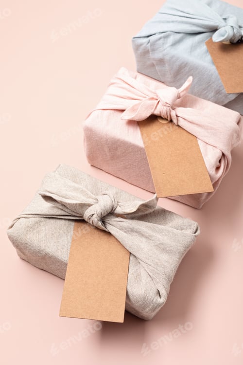 Preview: Zero waste gift wrapping traditional Japanese furoshiki style over pink background