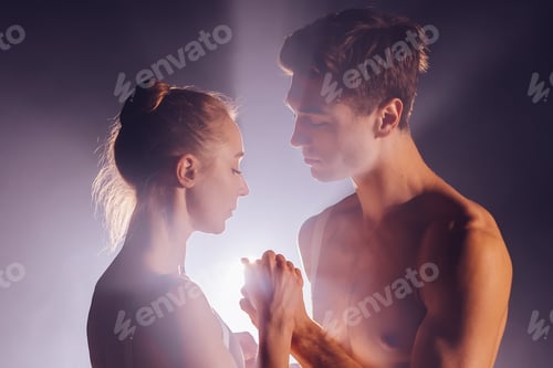 Vista previa: Romantic professional ballet pair practicing moves on dark stage. Young couple dancing