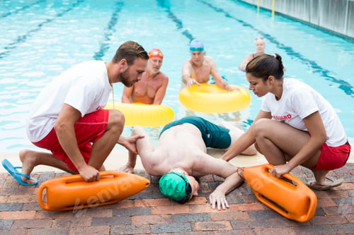 Preview: Male and female lifeguards helping unconscious man
