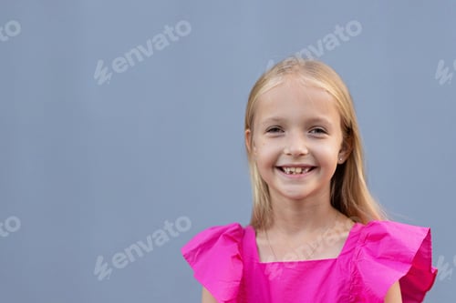 Preview: Candid portrait of cute little Caucasians blue-eyed girl with blonde hair in pink dress looking at
