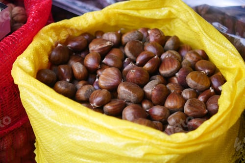 Preview: Chestnuts in a yellow bag at local market in autumn
