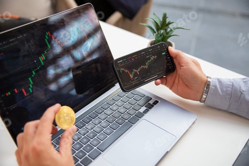 Preview: A cryptocurrency trader trades with his laptop and smartphone.