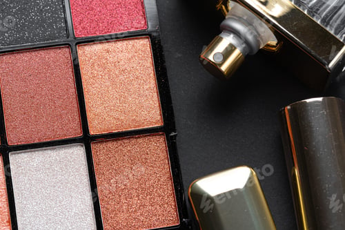 Preview: various makeup products on black texture background.