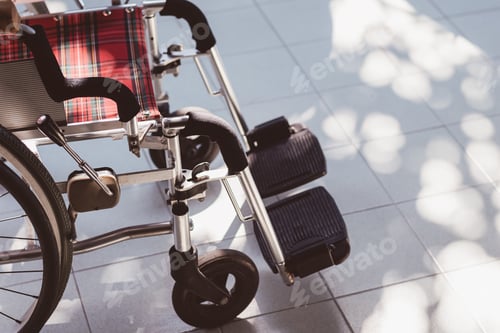 Vorschau: Nahaufnahme eines leeren Rollstuhls mit Tageslicht in der Natur auf weißem Fliesenboden, Handicap-Symbol, Niemand