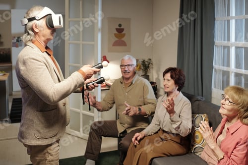 Preview: Senior man in vr headset holding gamepads while controlling picture on screen