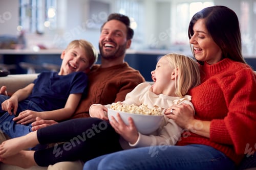 Happy Family Laughing and Eating Popcorn at Home