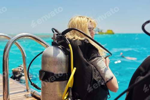 Preview: Young woman diver preparing for scuba diving