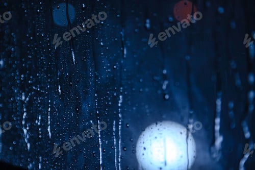 Preview: Abstract background with raindrops on window and night blurred light