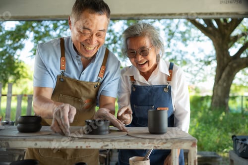 Preview: Portrait of a senior Asian couple doing activities together in the pottery workshop.