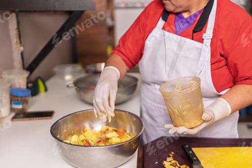 Preview: Woman preparing fried food in small restaurant kitchen