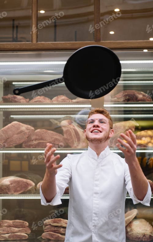 Preview: Chef in jacket with frying pan in air