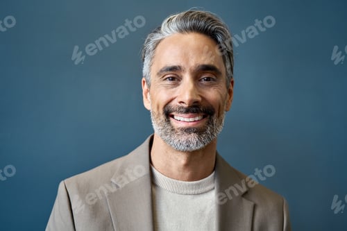 Preview: Happy mature business man looking at camera on grey wall, headshot portrait.