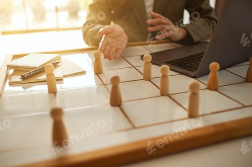 Preview: Businesswoman leader choosing and pointing at one of wooden people from a group of employees