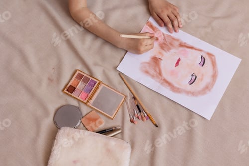 Preview: A small child girl draws a portrait with her mother's cosmetics.