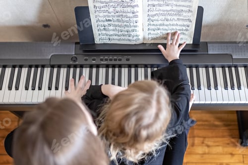 Preview: Mom and daughter play four-handed music on a synthesizer